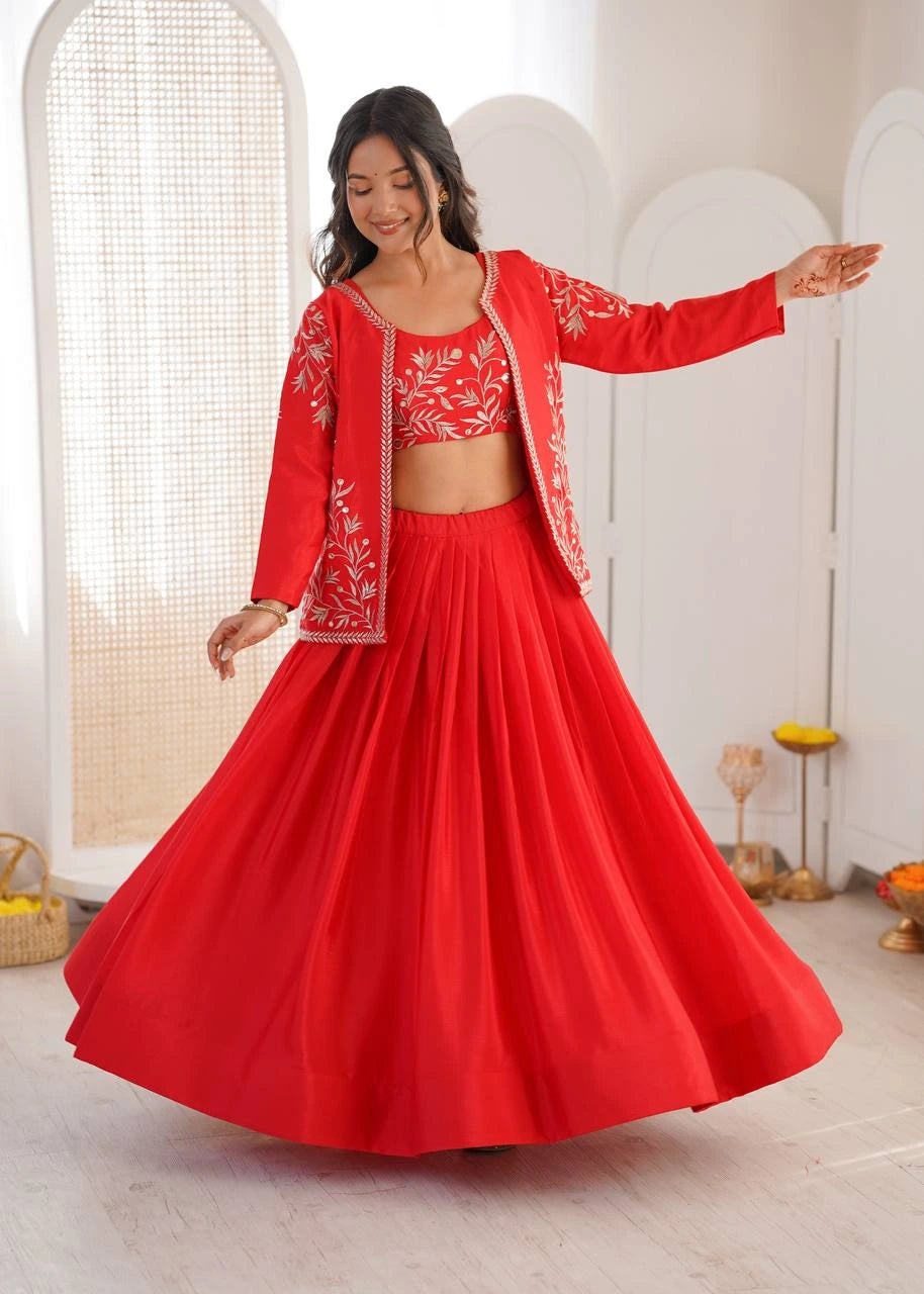 Woman in a red traditional outfit with white embroidery standing in a bright room.